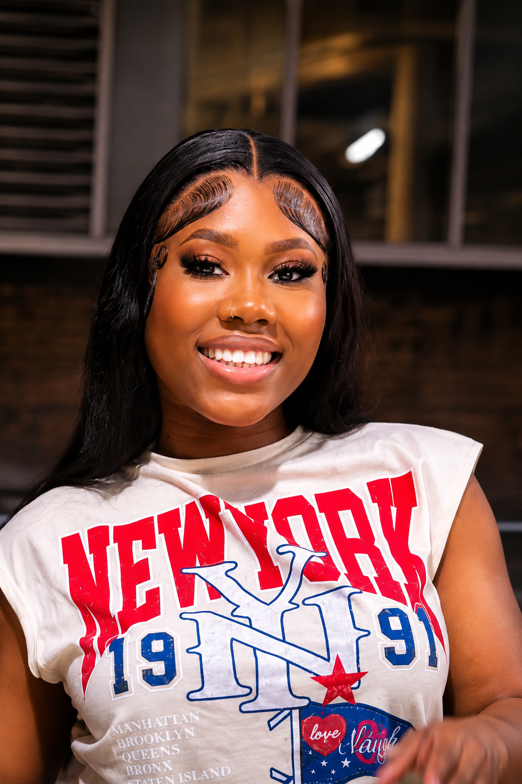 SoukaBeauty client smiling with a sleek jet-black lace wig install and laid edges